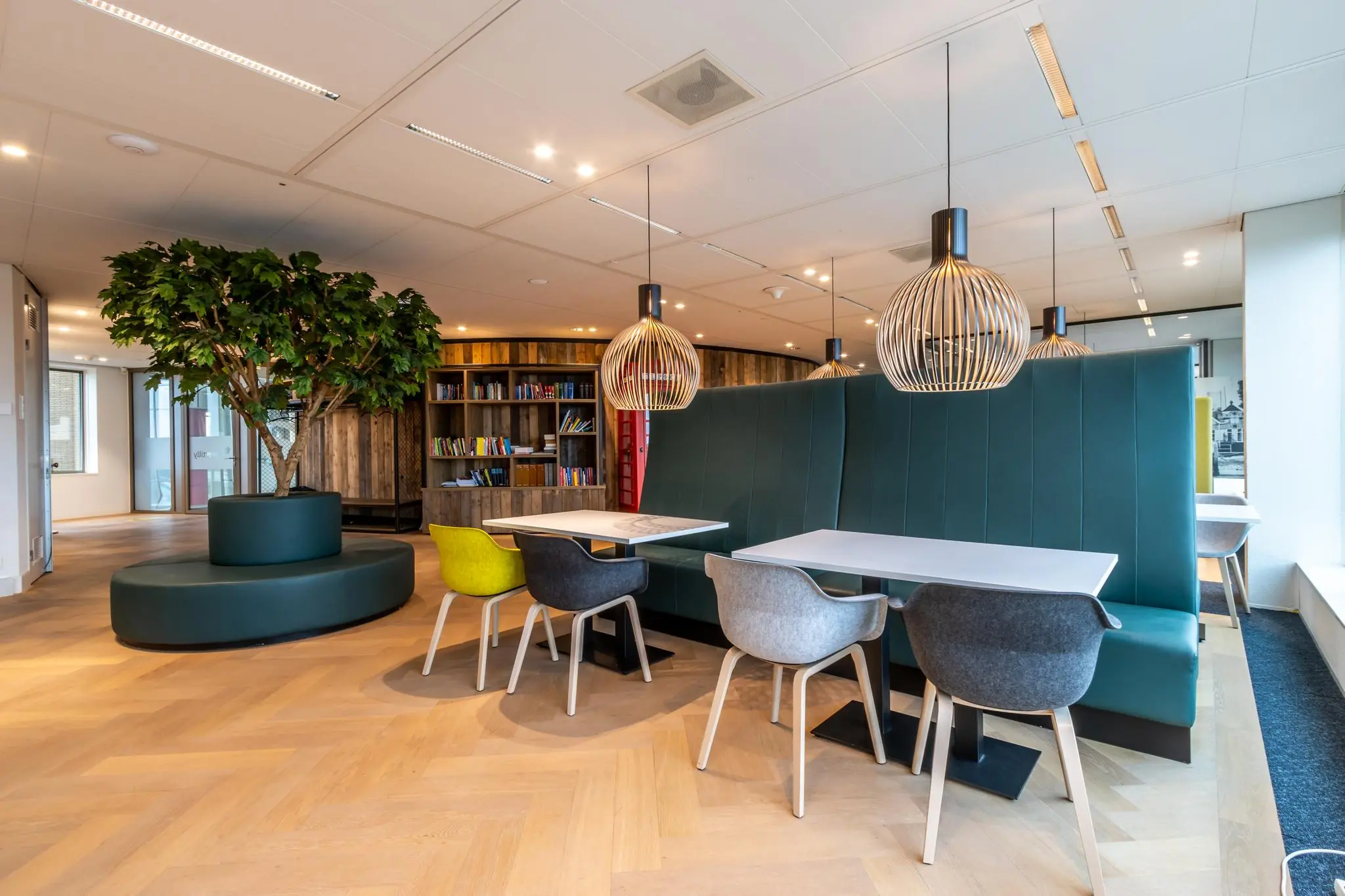 Moderne en sfeervolle kantoorruimte aan de Fascinatio Boulevard met zitjes, boekenwand en grote kamerplant.